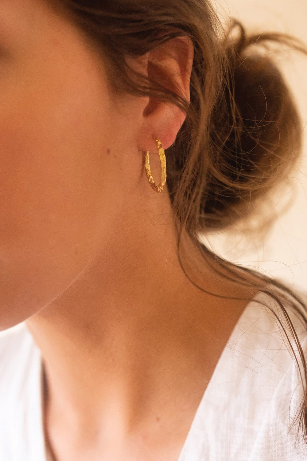 Textured gold thin hoop earrings, sterling silver core, close-up
