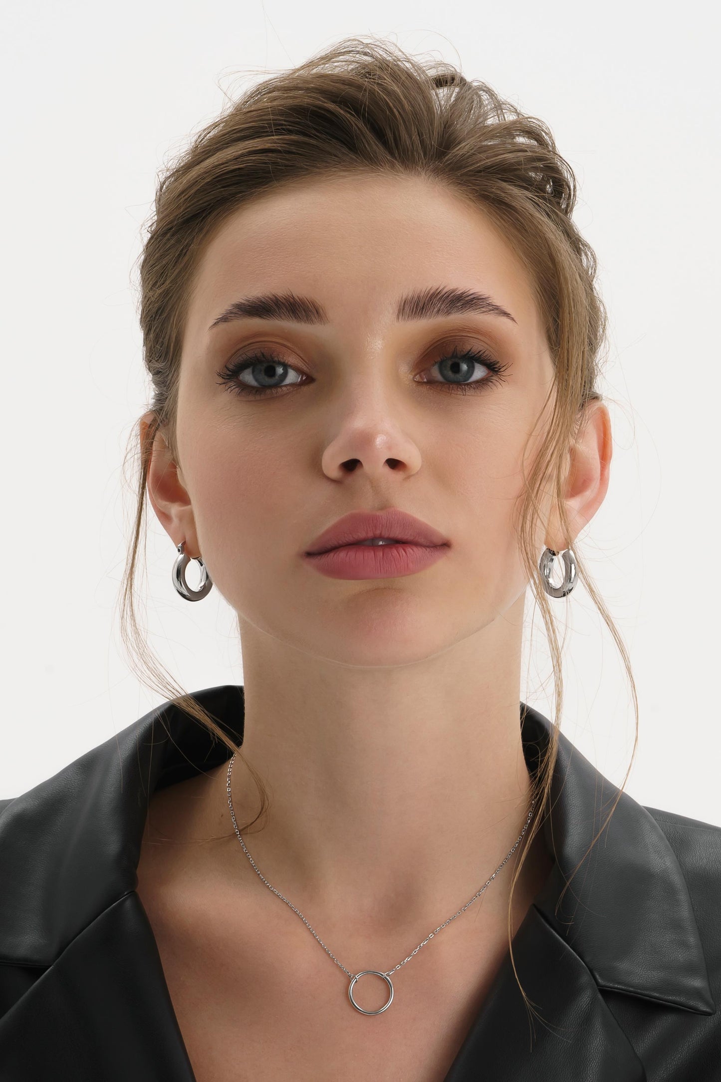 Gold circle necklace shown on a feminine neckline