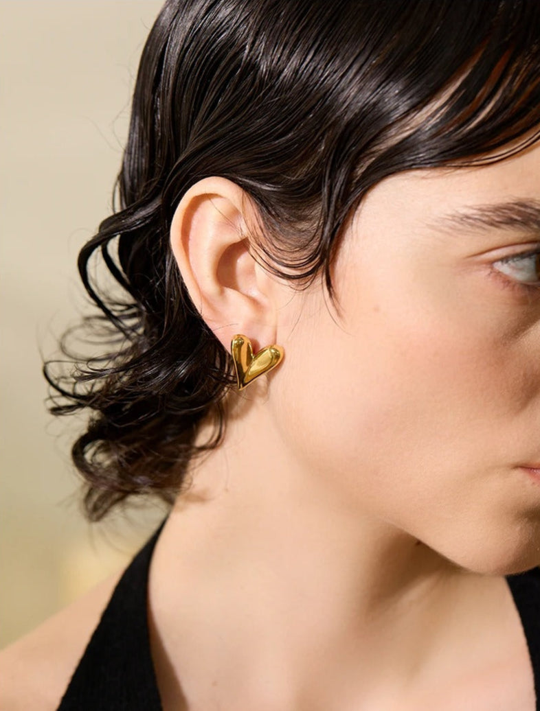 Heart-shaped gold drop earrings – close-up detail