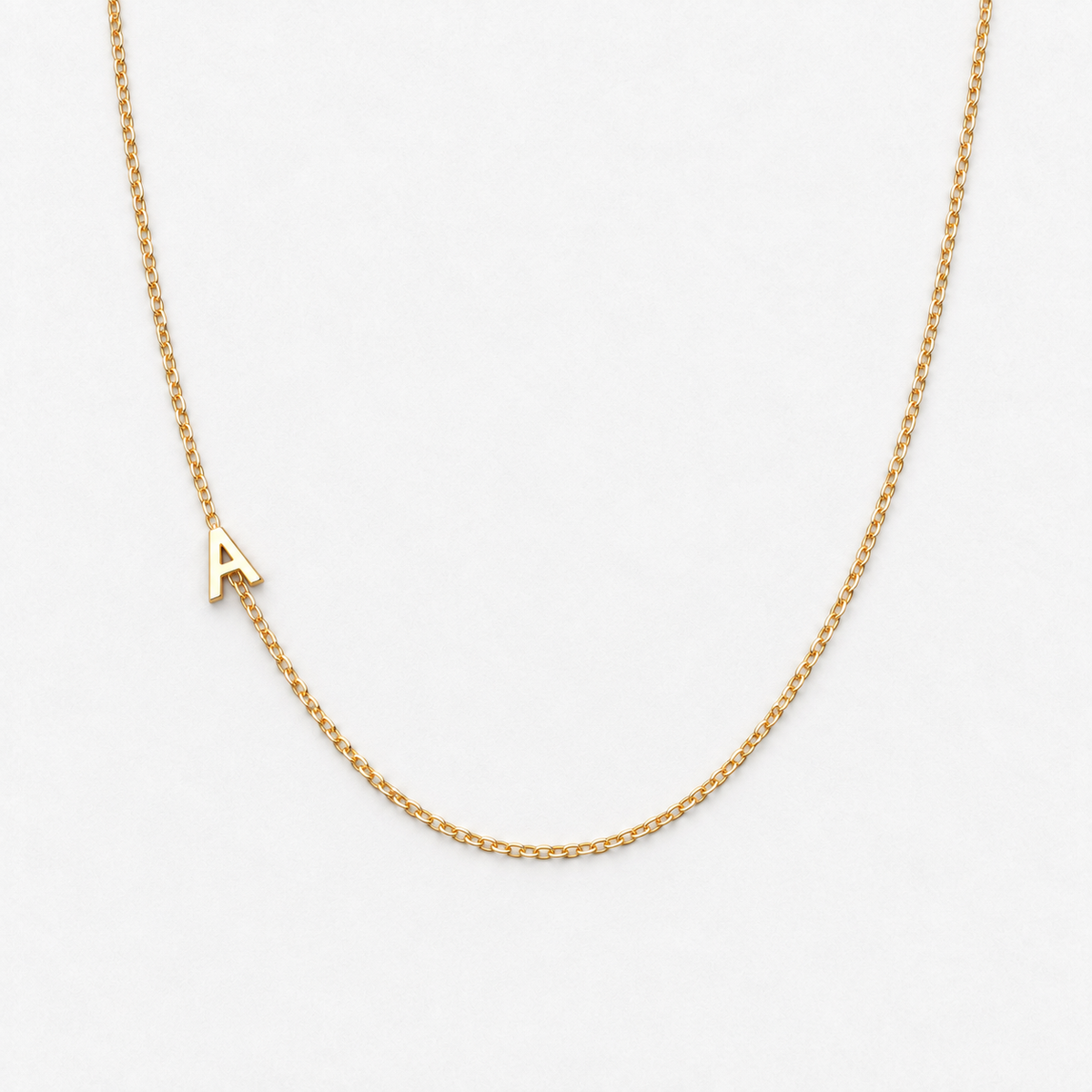 Plain sideways initial A necklace in gold colour photographed alone on the approved off-white background