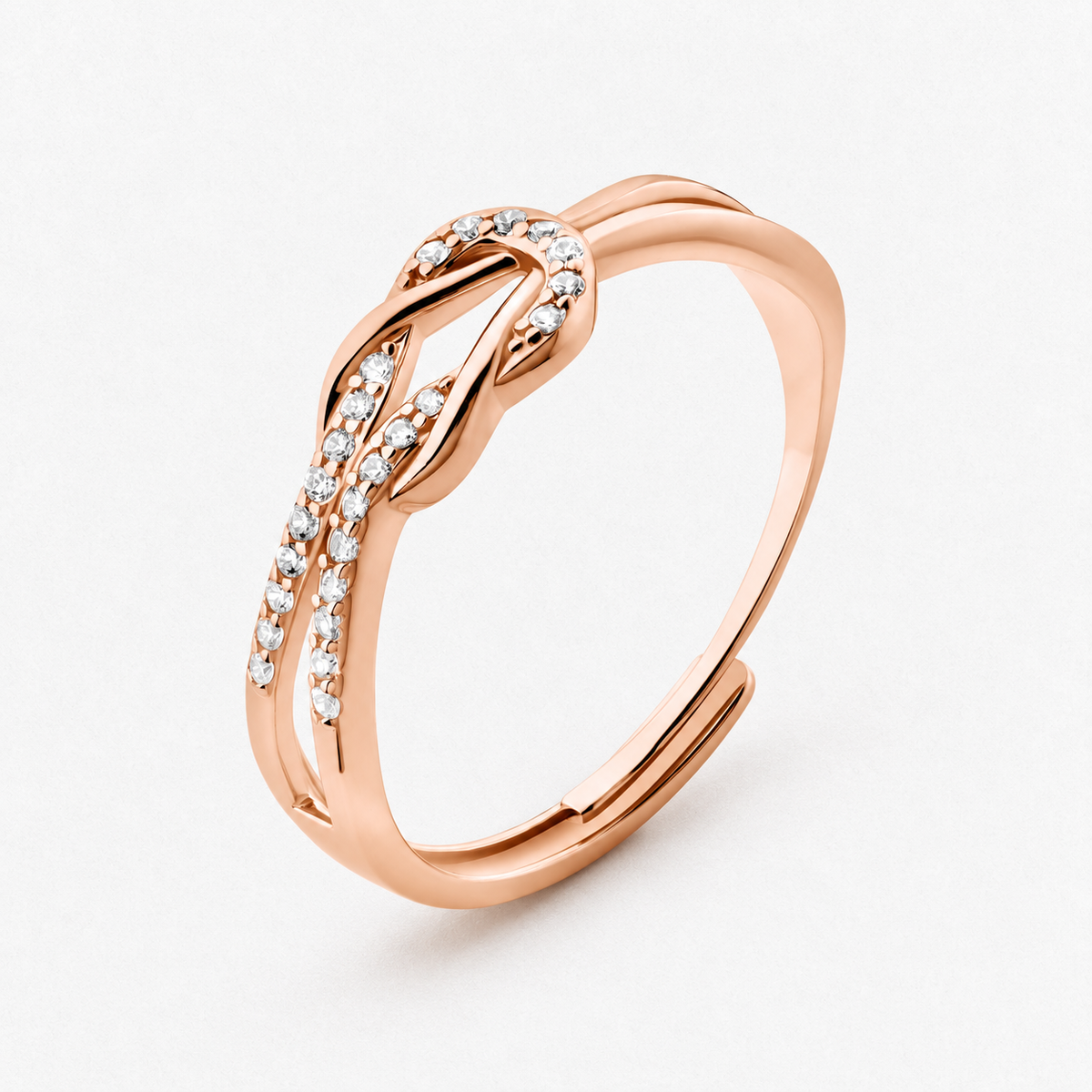 Knot adjustable ring with intertwined band and clear stone accents in a rose gold finish on a neutral off-white background.