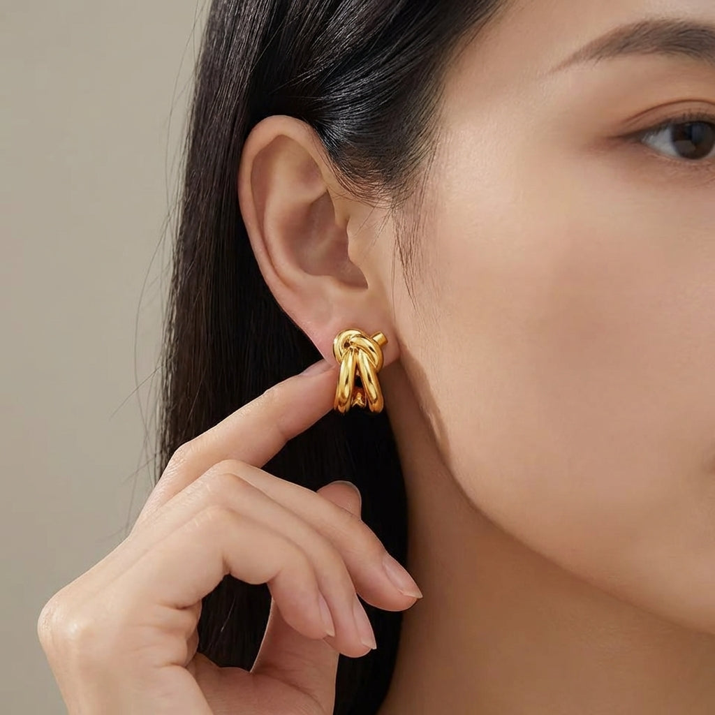 Knot huggie earrings styled on a model's ear