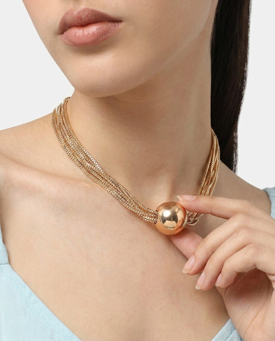 Layered gold necklace styled on a feminine neckline