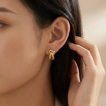 Close-up of gold knot huggie earring detail