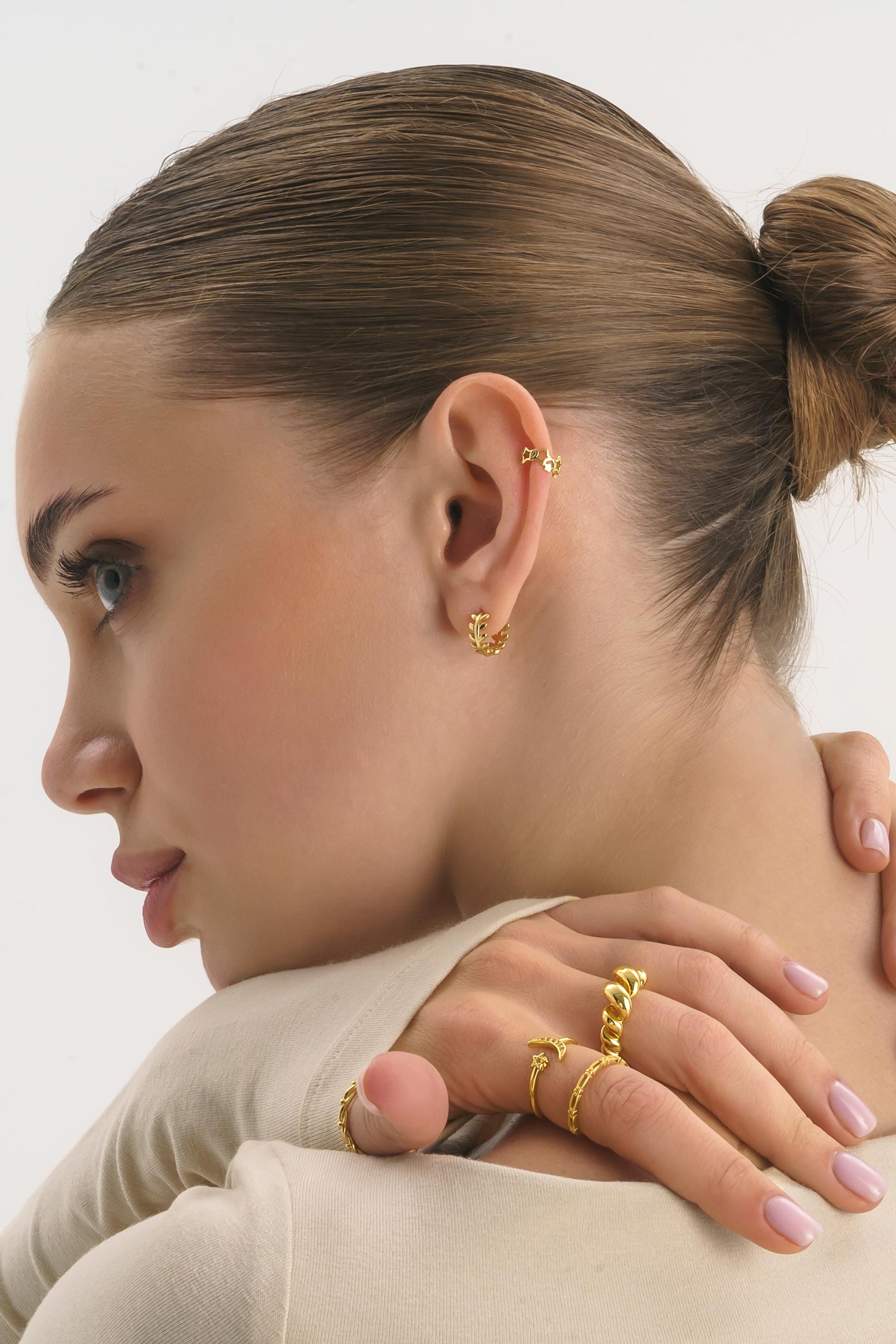 Gold tiny huggie hoop earrings, side angle view showing latch closure