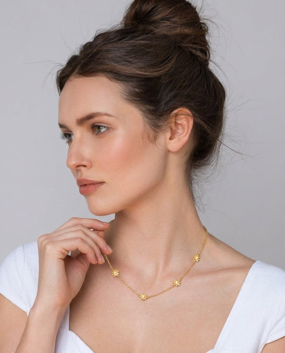 Close-up of delicate gold flower pendants on choker chain