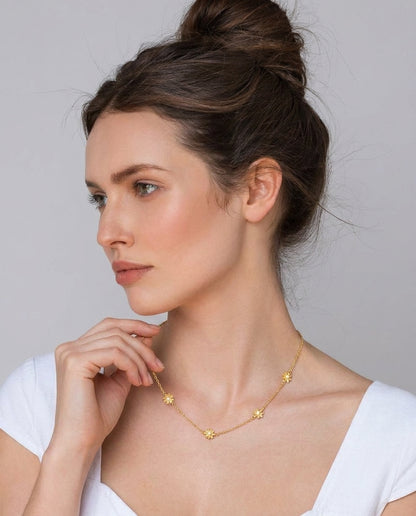 Close-up of delicate gold flower pendants on choker chain