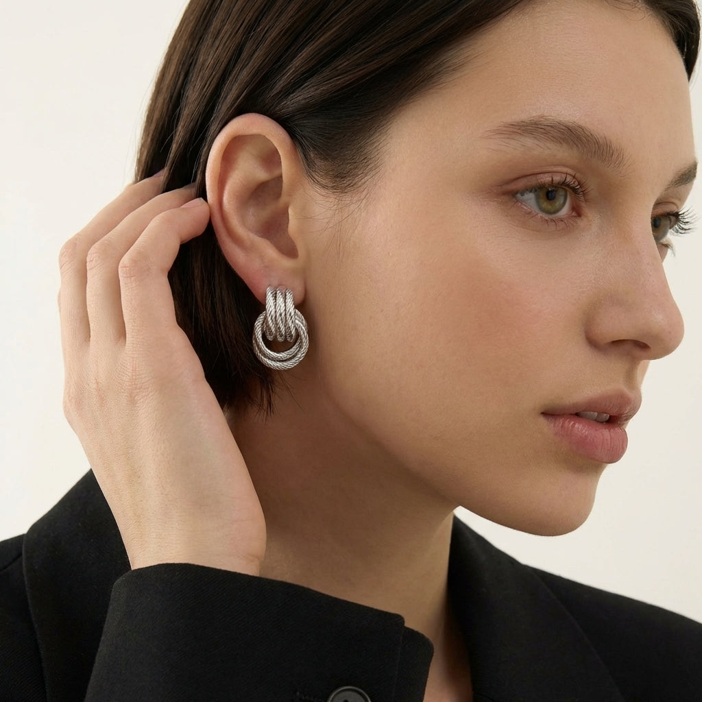 Close-up of polished gold knot earring — twisted sculptural detail