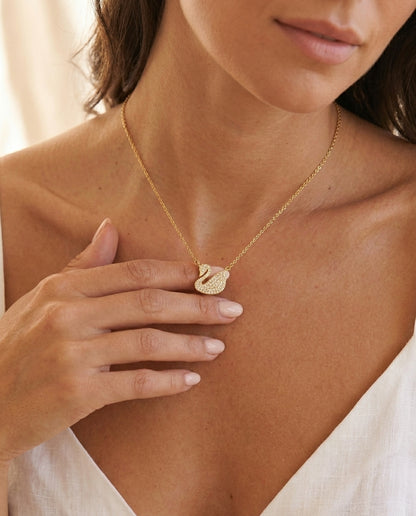 Gold swan pendant necklace with crystal accents — layered jewellery styling