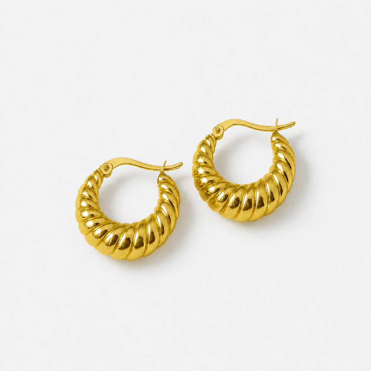 Nora gold-coloured croissant hoop earrings photographed as a pair on a light neutral background
