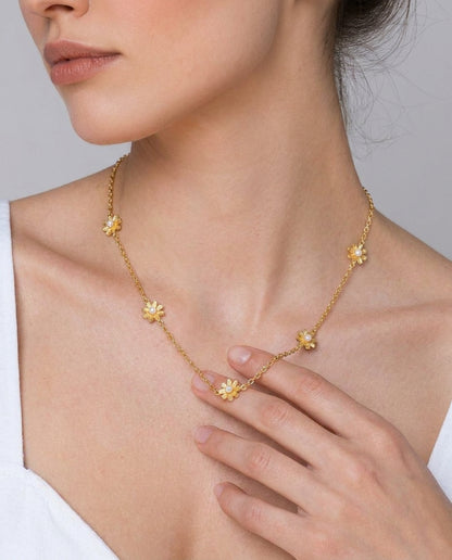 Gold flower choker necklace styled on a feminine neckline