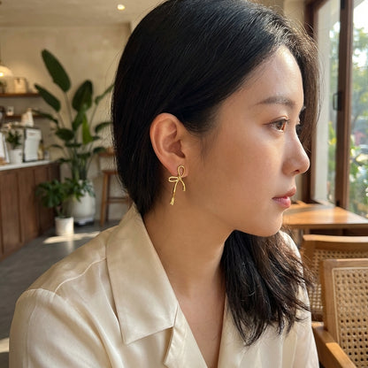 Gold bow drop earrings – side view