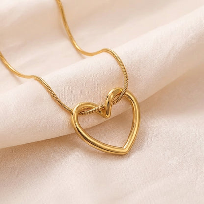 Gold heart necklace shown with elegant outfit