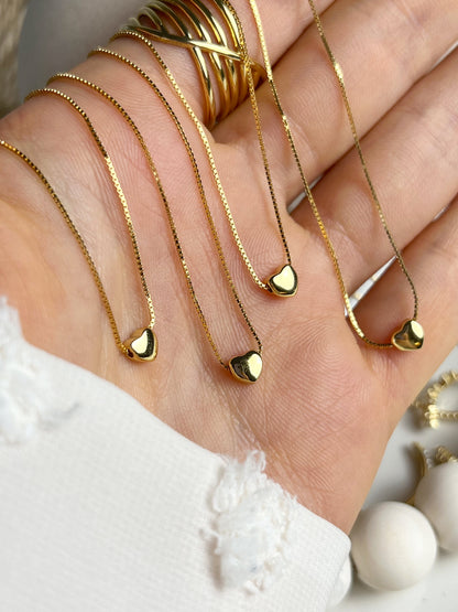 Gold heart pendant necklace, side angle view