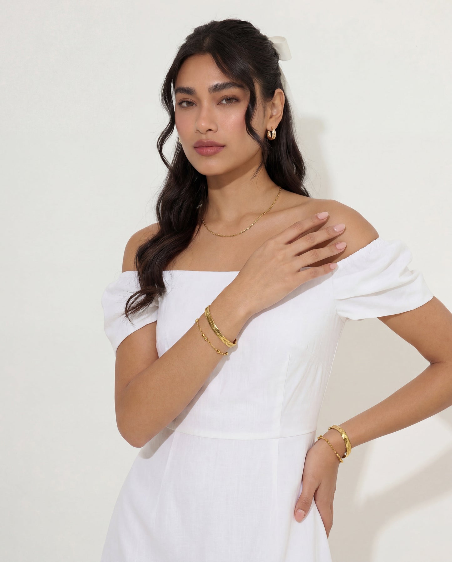 Gold satellite chain bracelet styled with matching gold necklace, layered look