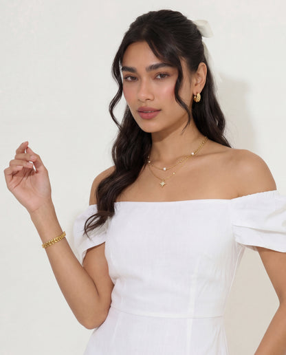 Gold leaf chain bracelet layered with other delicate gold chains