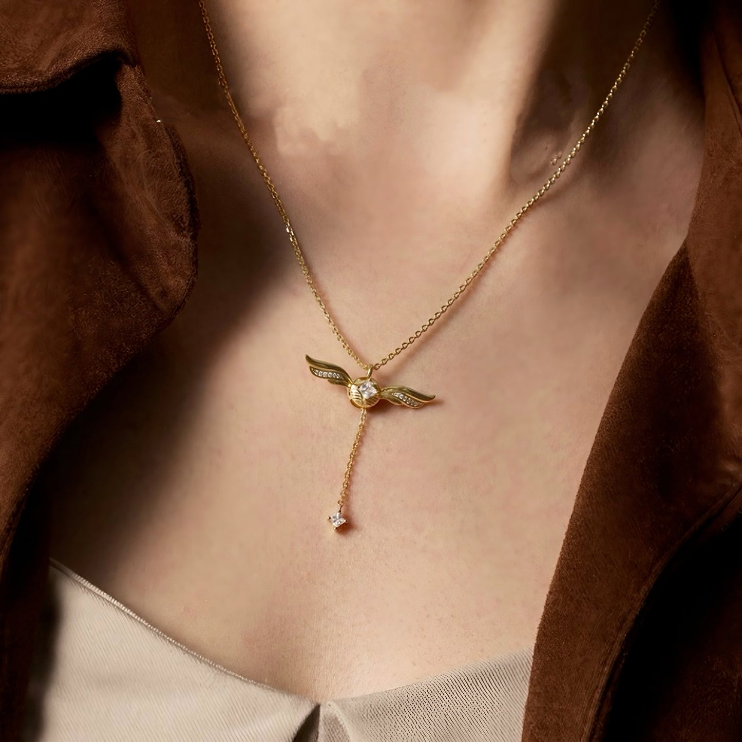 Gold-plated lariat necklace with winged pendant, front view