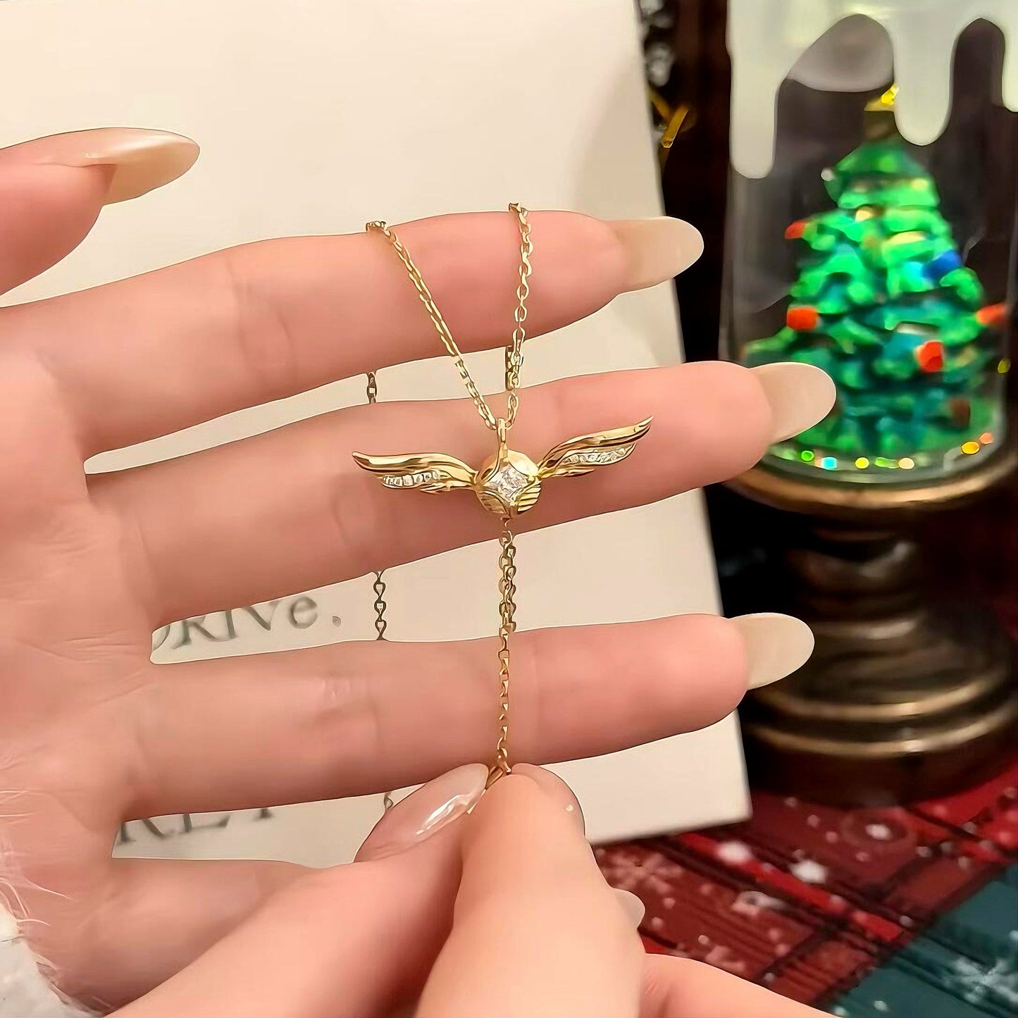 Gold lariat necklace with winged pendant, feminine jewellery by Ravyena