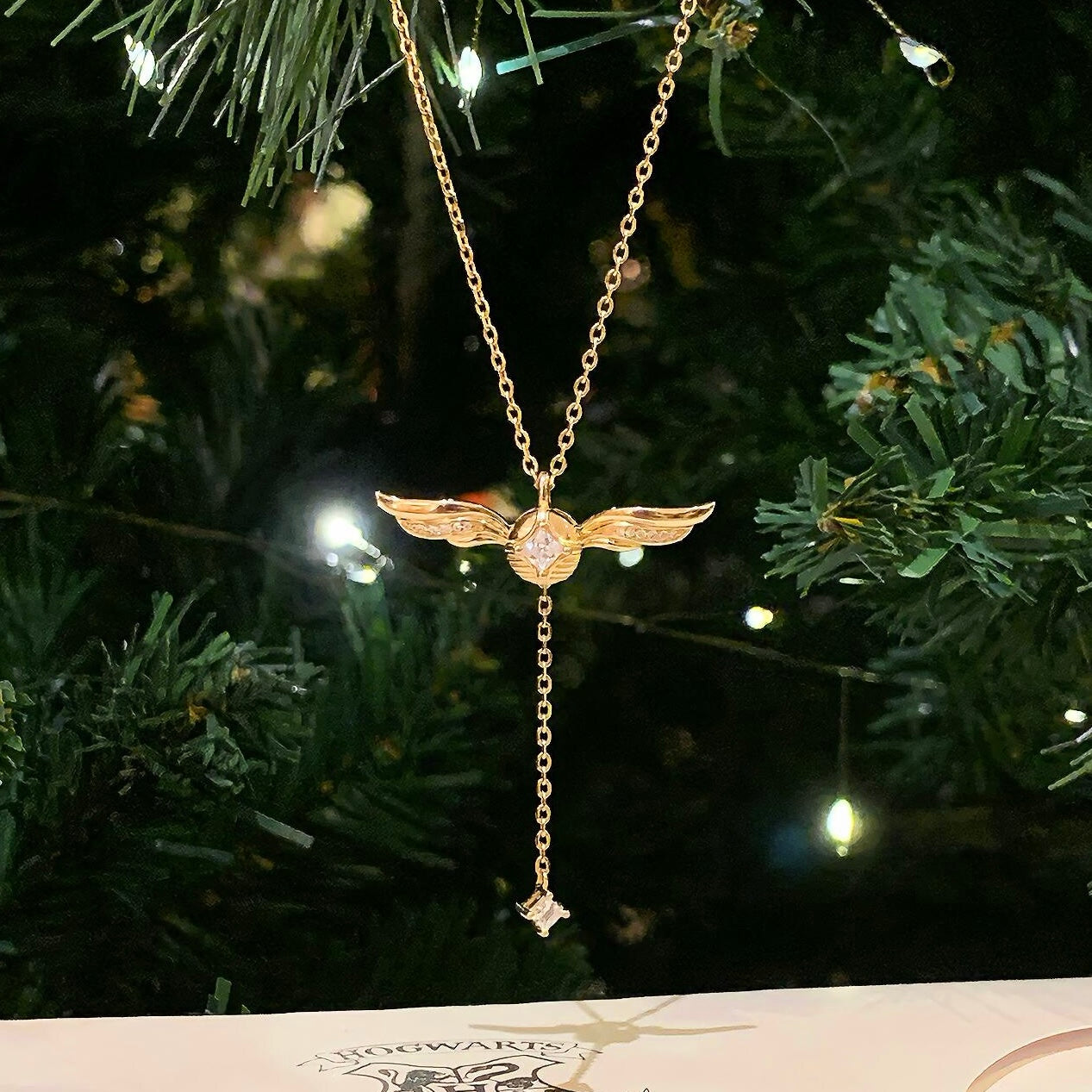 Winged pendant detail on gold-plated lariat necklace with cubic zirconia