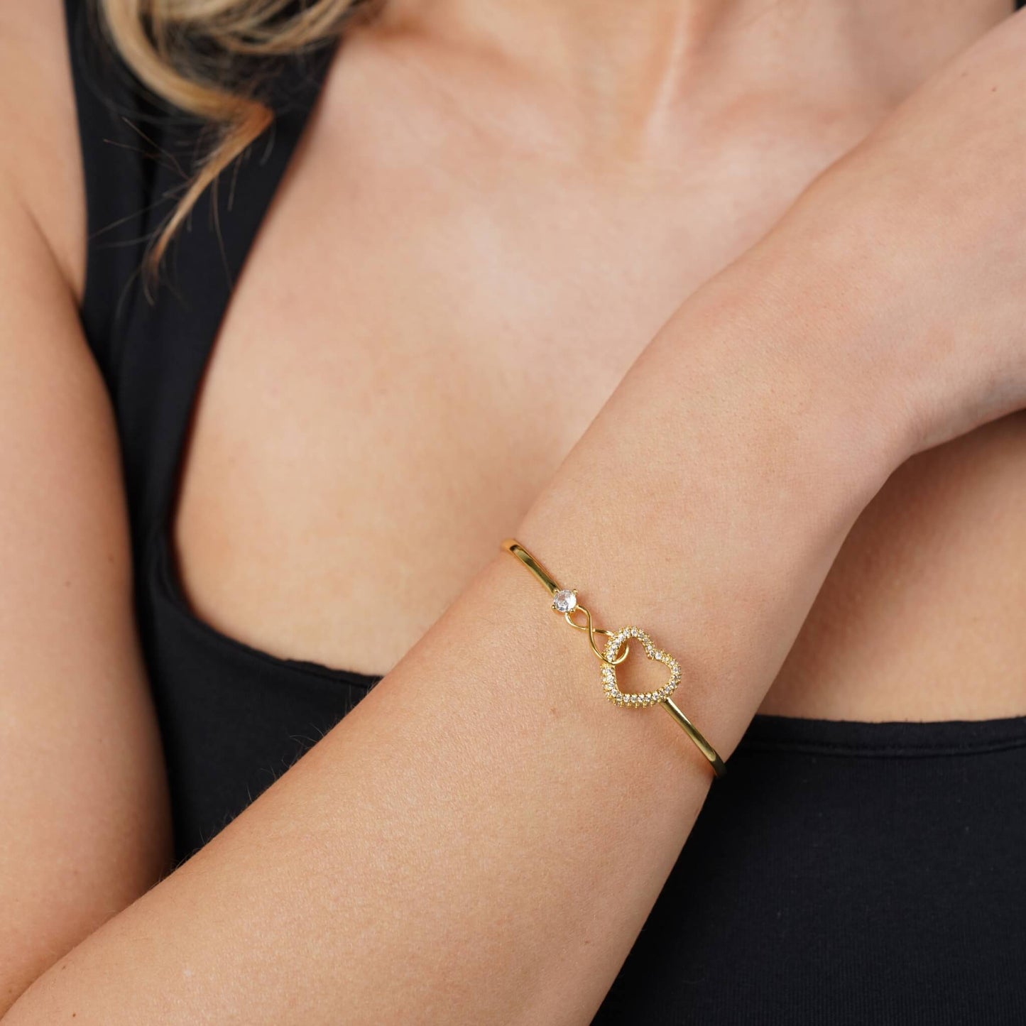 Interlocking infinity and heart charms in gold, close-up detail