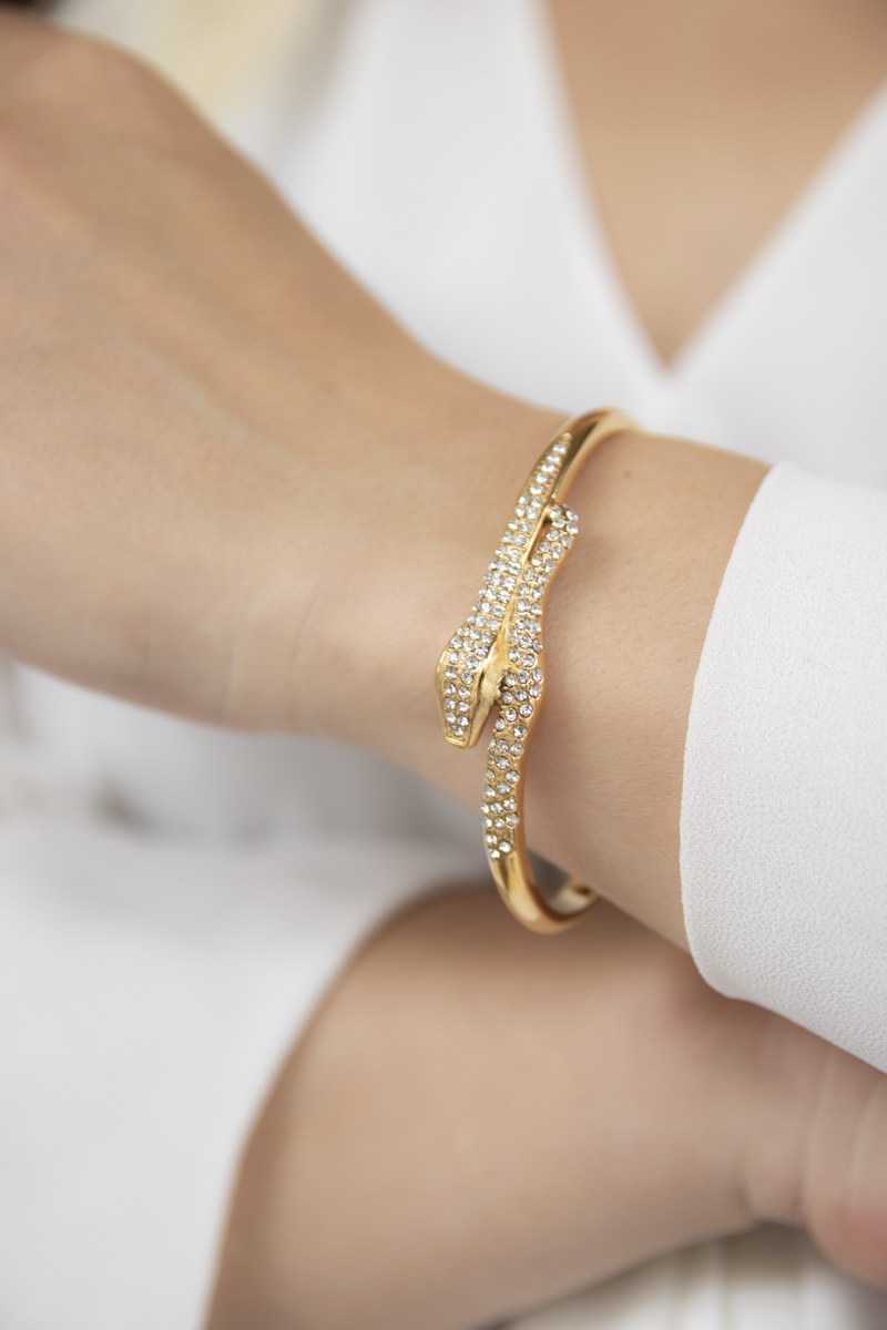 Gold twisted cuff bracelet on a model's arm, refined elegance