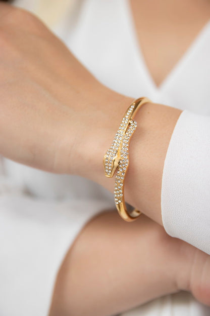 Gold twisted cuff bracelet on a model's arm, refined elegance