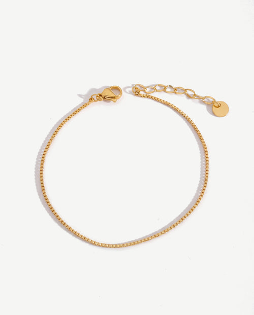 Tiny 14K gold keel chain link bracelet on a feminine wrist