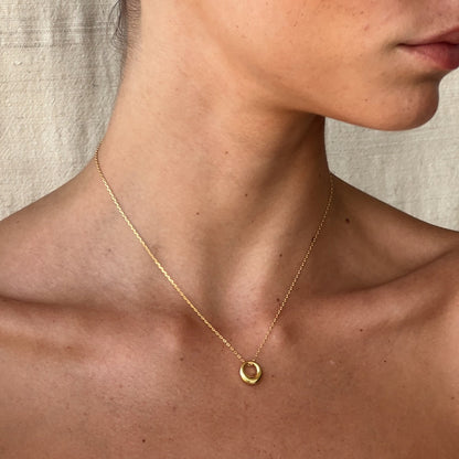 Close-up of tapered gold circle pendant detail