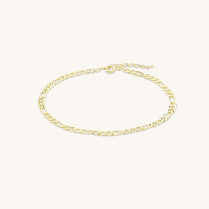 Close-up of gold figaro chain bracelet detail