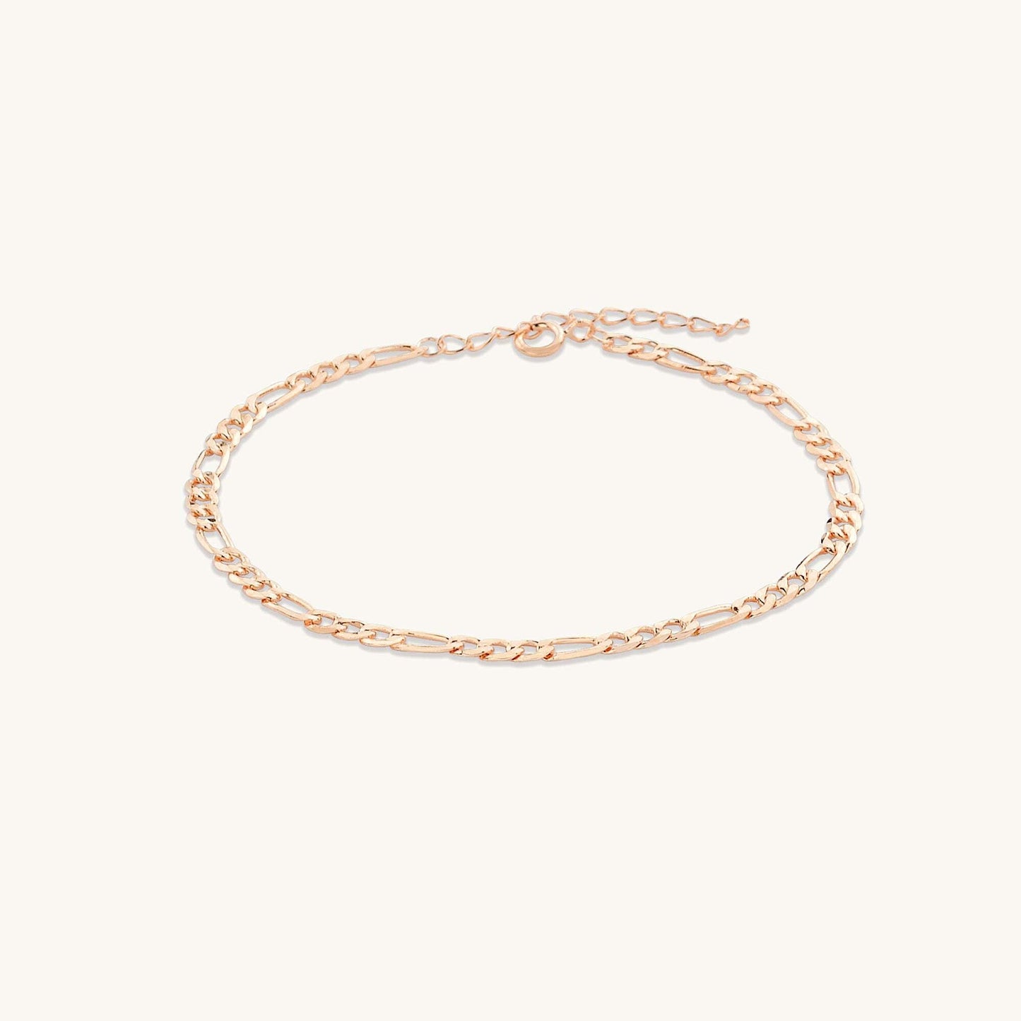Gold figaro chain bracelet on neutral background