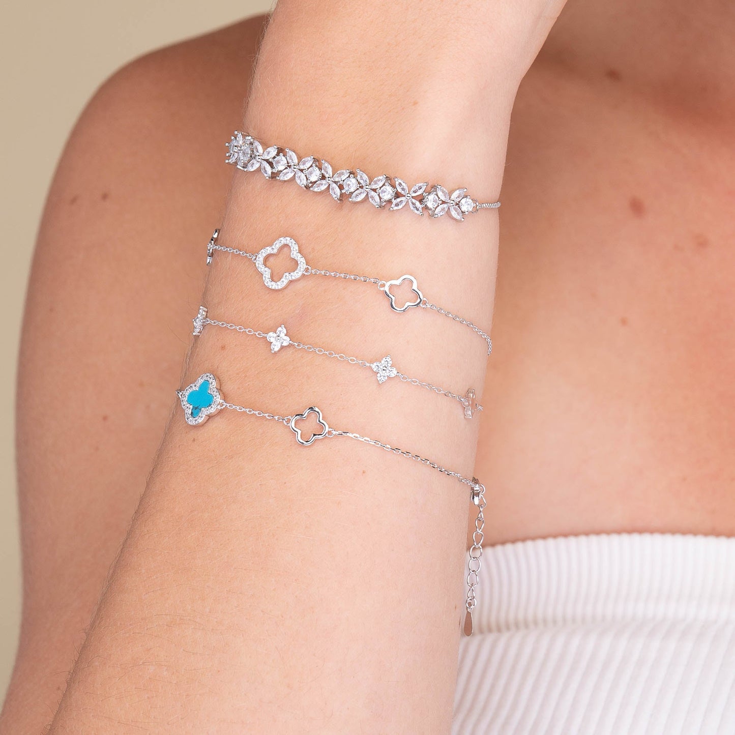 Clover charm bracelet shown with elegant outfit