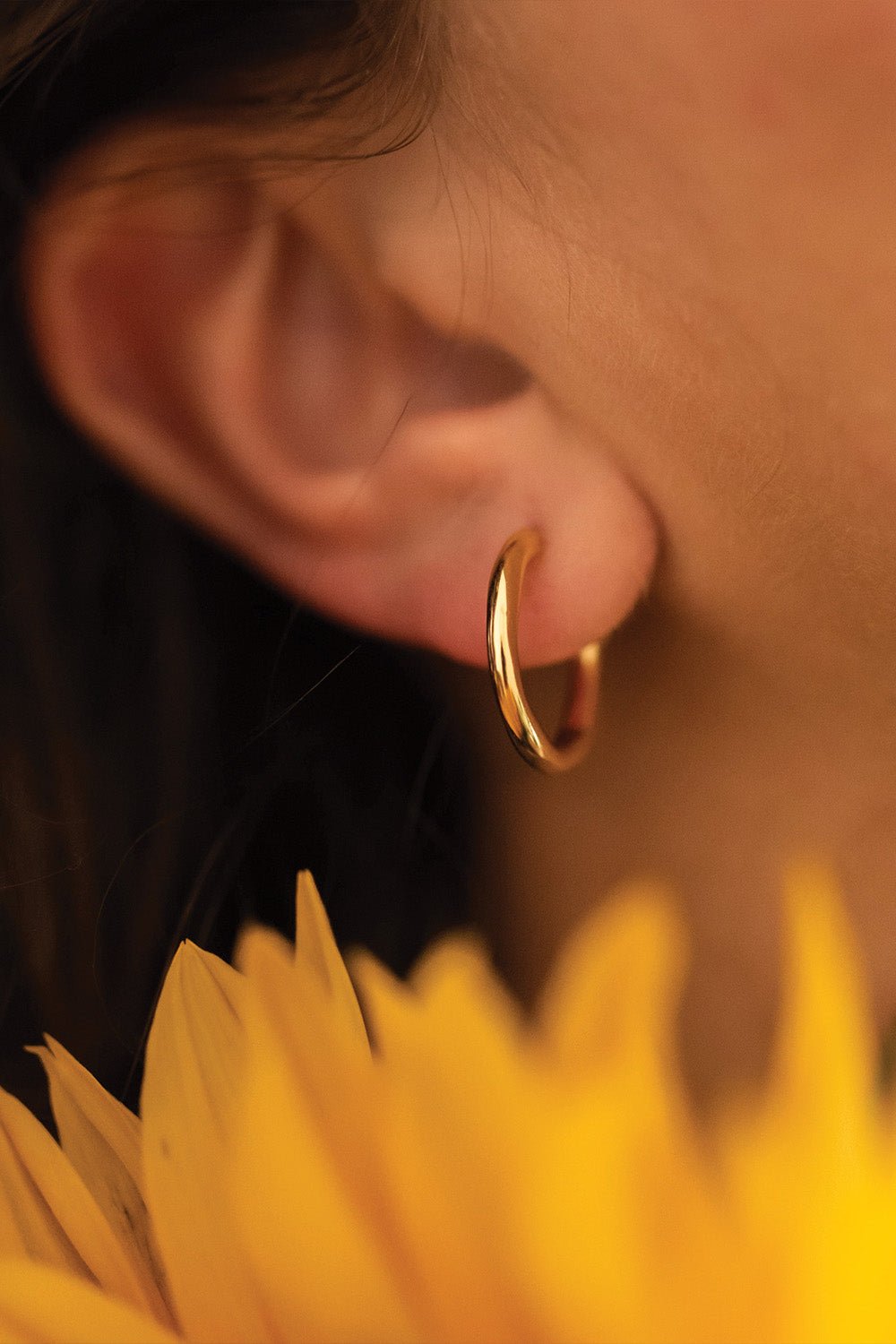 Dainty 14K Gold Hoop Earrings styled on model ear – Ravyena