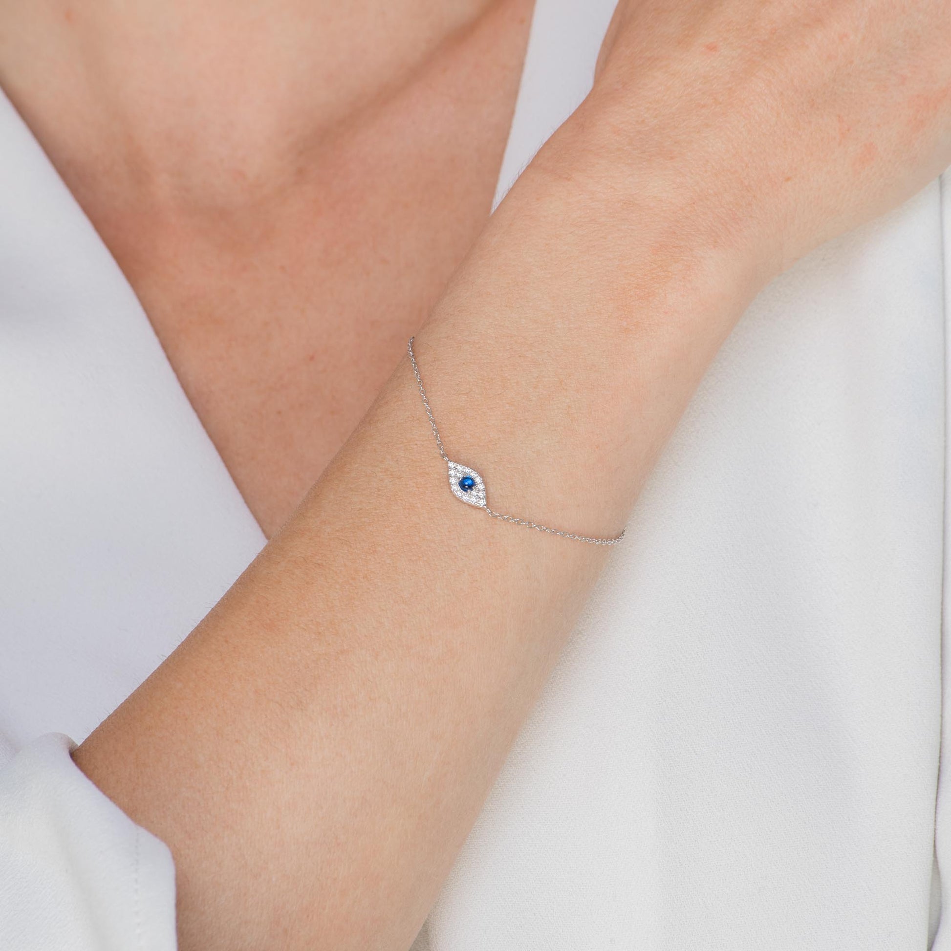 Multiple evil eye charms on gold pave bracelet