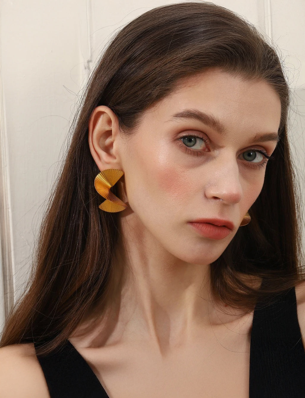Sculptural gold spiral drop earrings, sun-inspired design