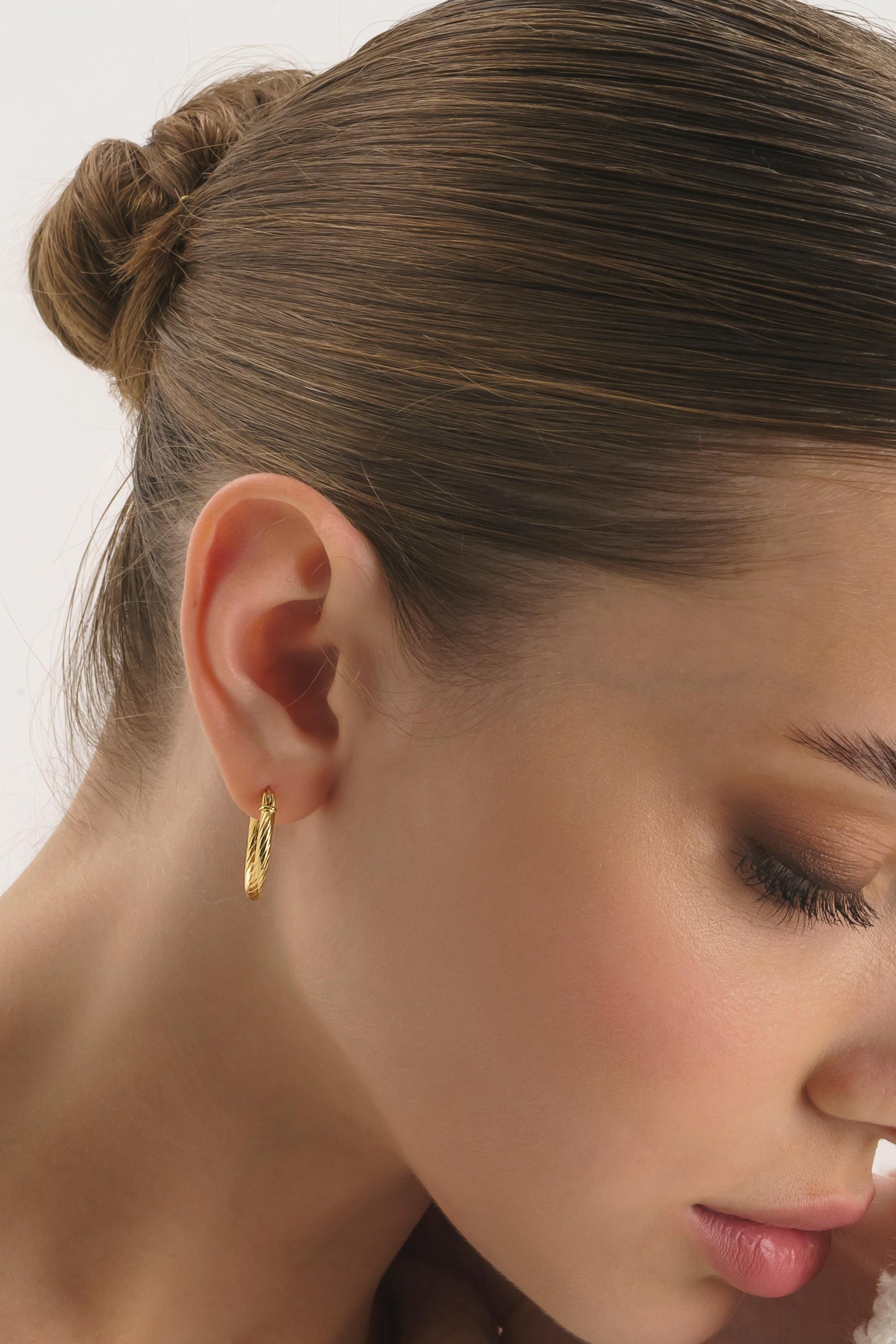 14K gold twist huggie hoops with secure latch closure