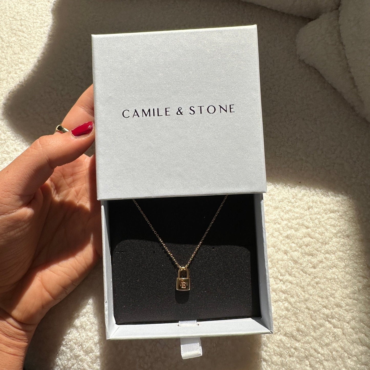 Padlock initial necklace styled on a feminine neckline