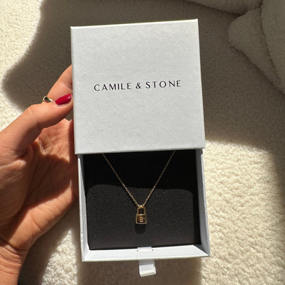 Padlock initial necklace styled on a feminine neckline