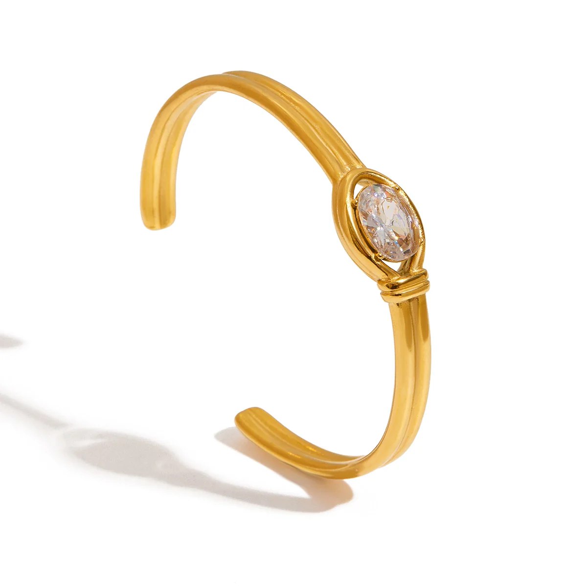 Gold cuff bracelet with luminous oval crystal stone