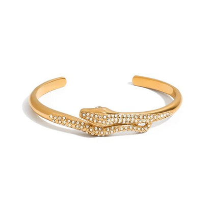 Gold twisted cuff bracelet on a feminine wrist, sculptural design