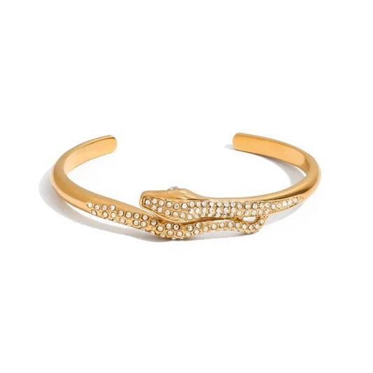 Gold twisted cuff bracelet on a feminine wrist, sculptural design