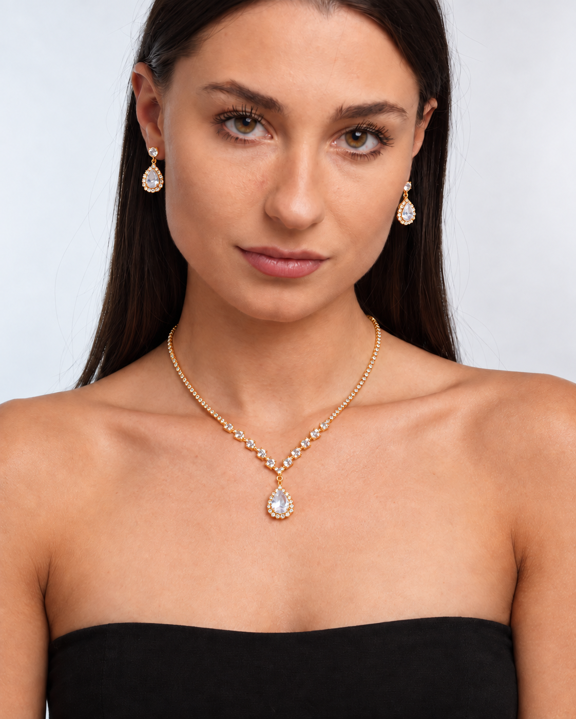 Crystal Teardrop Necklace & Earring Set in Gold / Clear, worn by a model in a front portrait - Ravyena