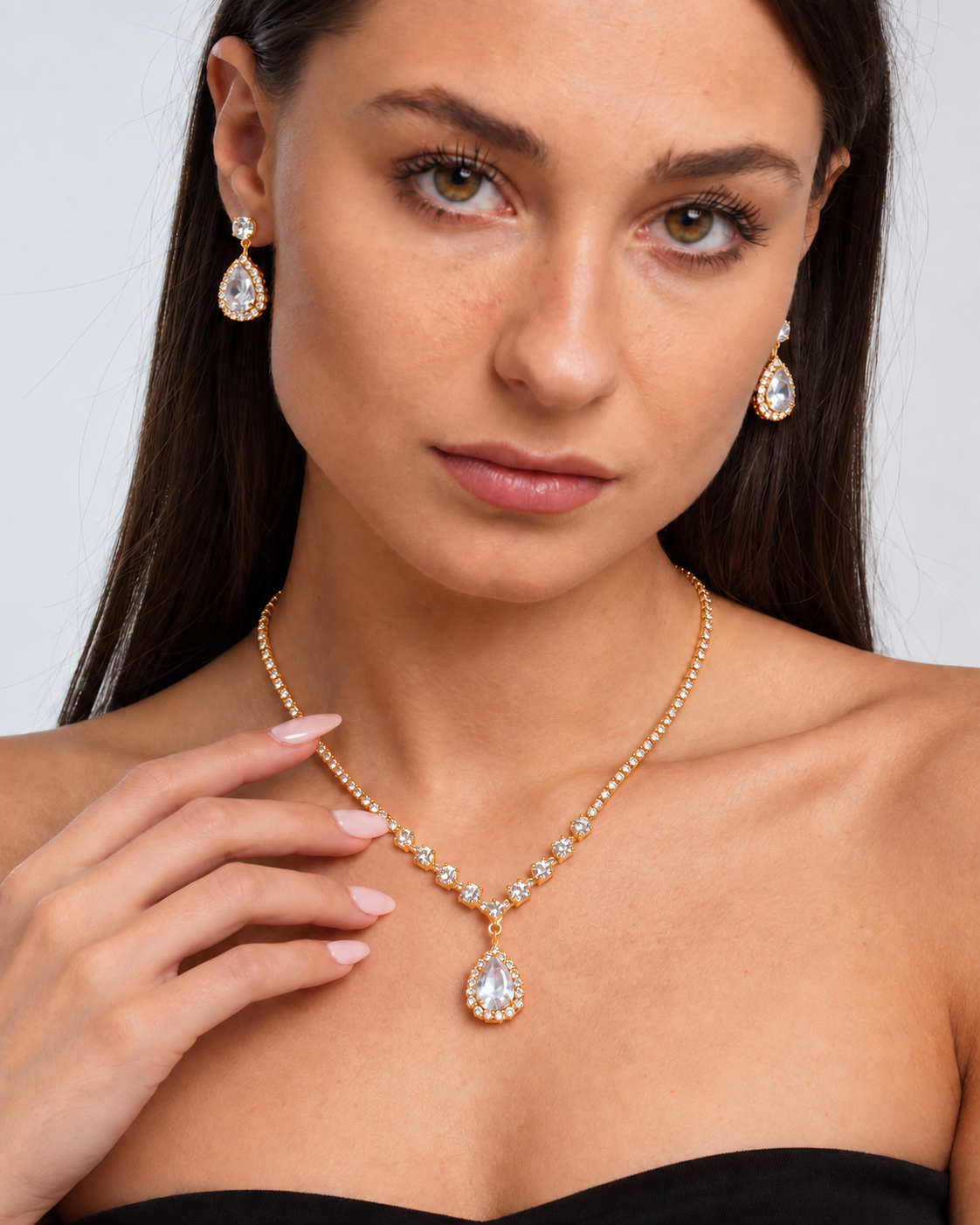 Crystal Teardrop Necklace & Earring Set in Gold / Clear, worn by a model in a close-up - Ravyena