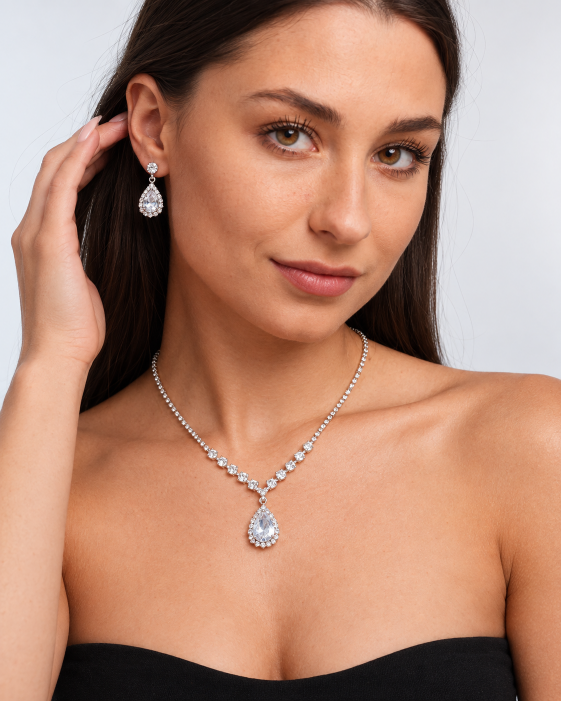 Crystal Teardrop Necklace & Earring Set in Silver / Clear, worn by a model in a three-quarter portrait - Ravyena