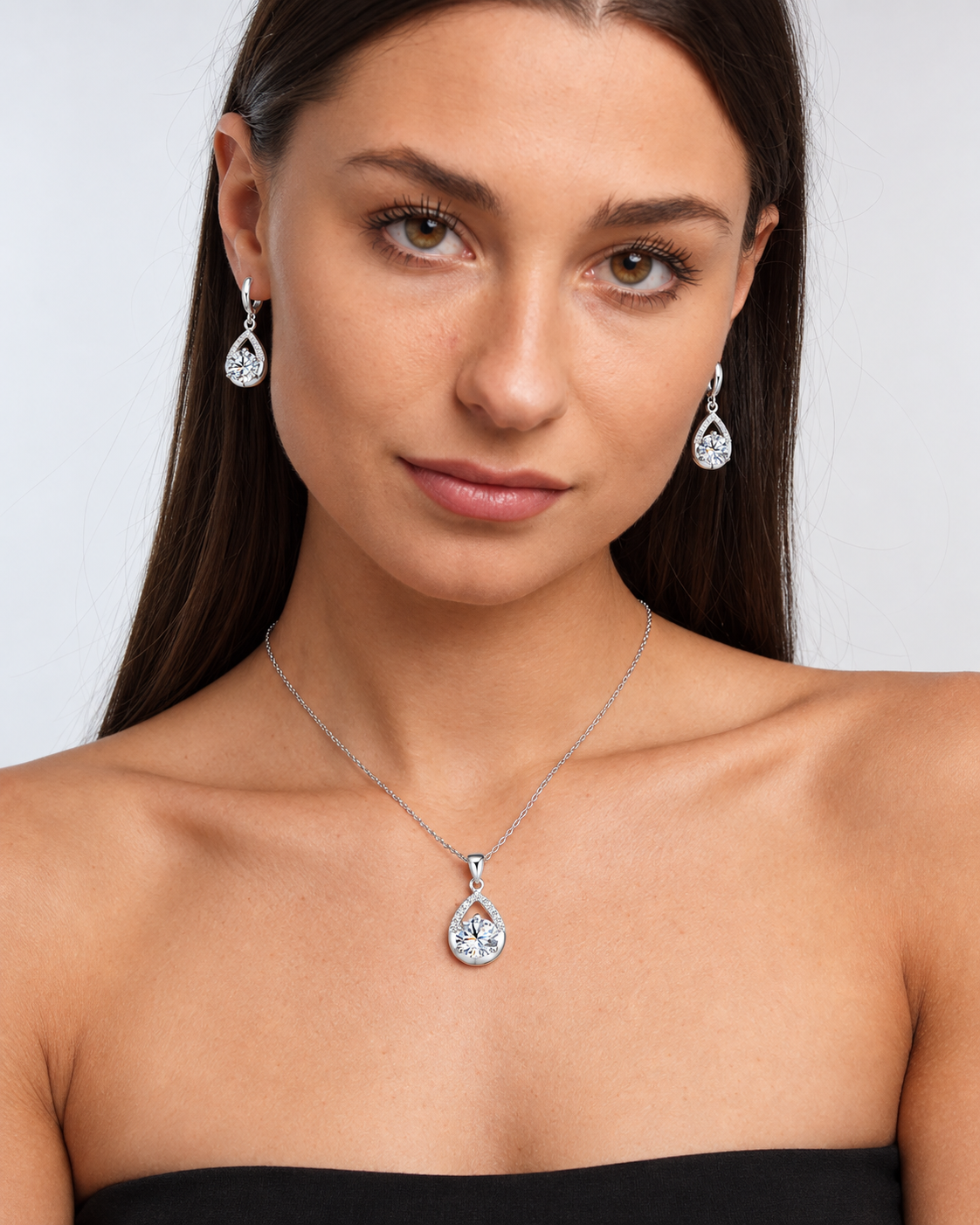 Silver-Tone Teardrop Crystal Necklace & Earring Set in Clear, worn by a model in a front portrait - Ravyena