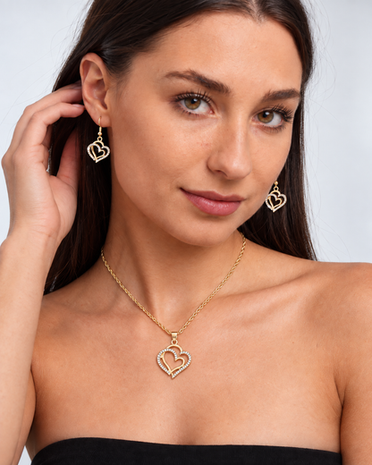 Double Heart Crystal Necklace & Earring Set in Gold, worn by a model in a three-quarter portrait - Ravyena