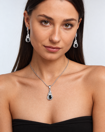 Black Crystal Twist Necklace & Earring Set in Black, worn by a model in a front portrait - Ravyena