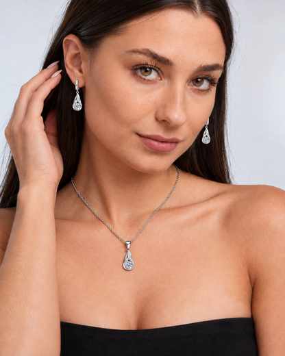 Twist Teardrop Crystal Necklace & Earring Set in Clear, worn by a model in a three-quarter portrait - Ravyena