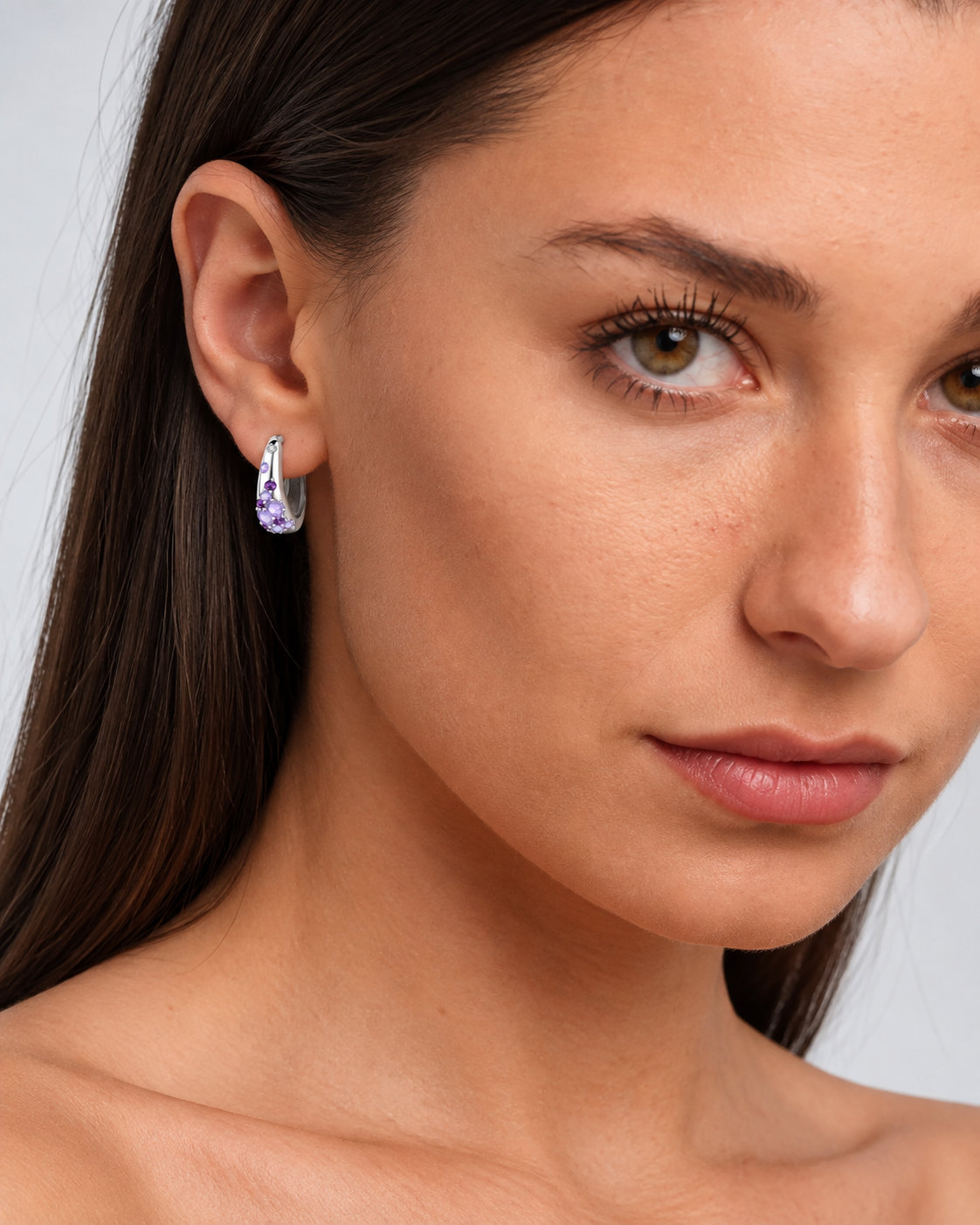 Sterling Silver Colour Crystal Hoop Earrings in Purple, worn by a model in a close-up - Ravyena