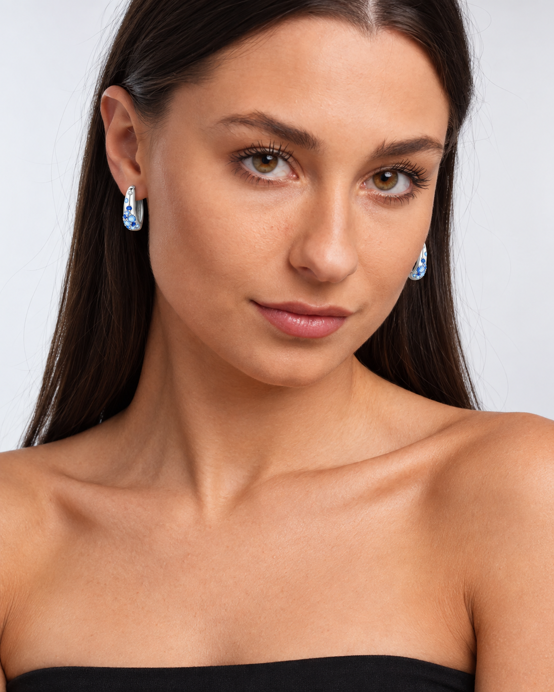 Sterling Silver Colour Crystal Hoop Earrings in Blue, worn by a model in a front portrait - Ravyena