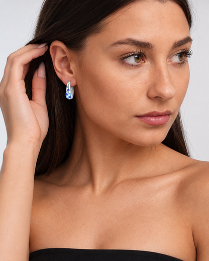 Sterling Silver Colour Crystal Hoop Earrings in Blue, worn by a model in a three-quarter portrait - Ravyena